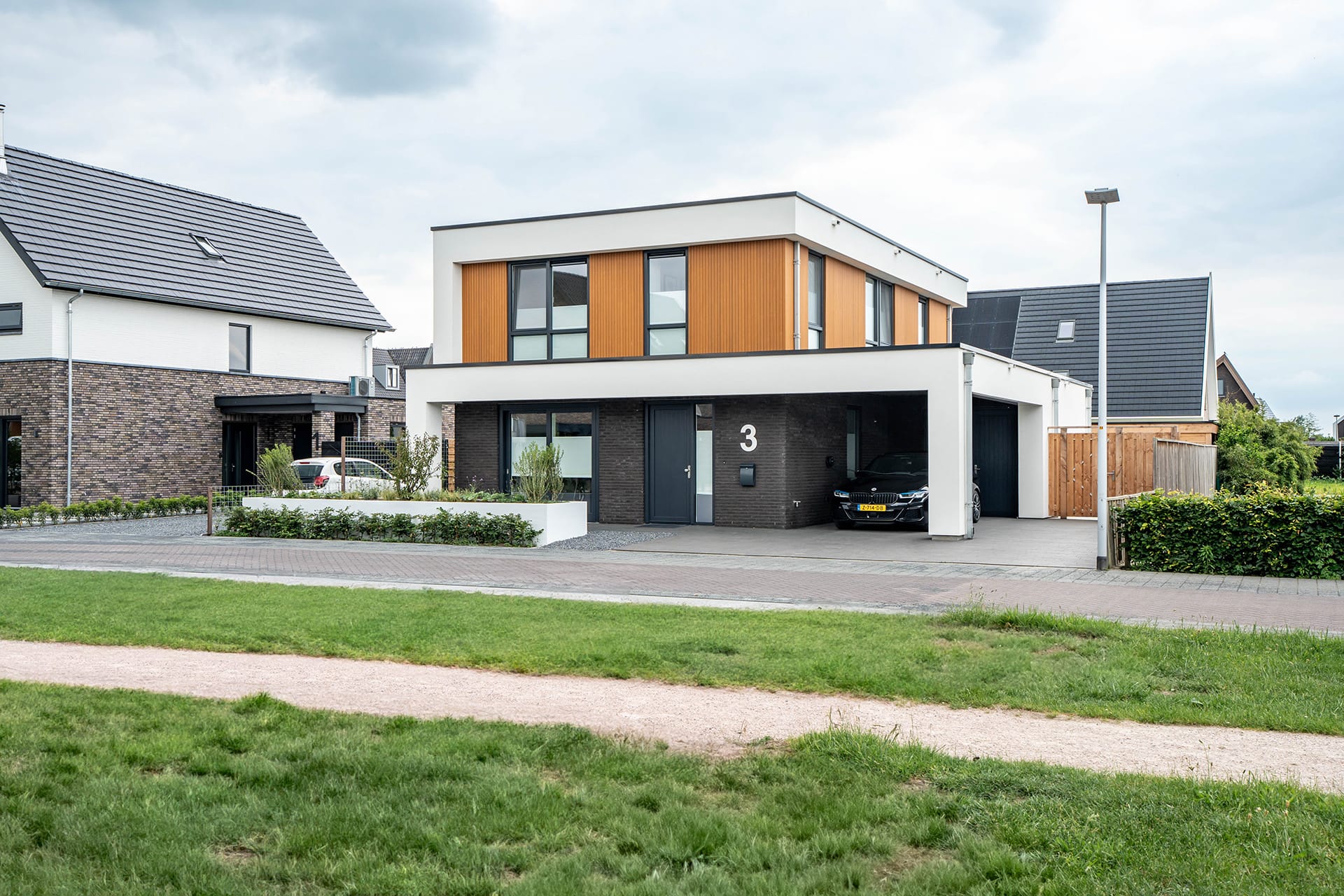 Kubistische woning met witte accenten en houten gevelbekleding